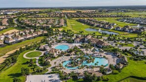Um campo de golfe com vários lagos e uma área de natação central rodeada por edifícios residenciais.