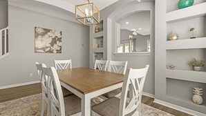 A dining room with a wooden table and white chairs, a chandelier, and a decorative wall with shelves. - Last Minute Disney! Private Pool, Hot Tub, Game Room & Themed Bedrooms. Book Now! #113671 (Orlando)