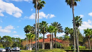 A hotel with a red-tiled roof, surrounded by palm trees and a well-maintained garden. - Last Minute Disney! Private Pool, Hot Tub, Game Room & Themed Bedrooms. Book Now! #113671 (Orlando)