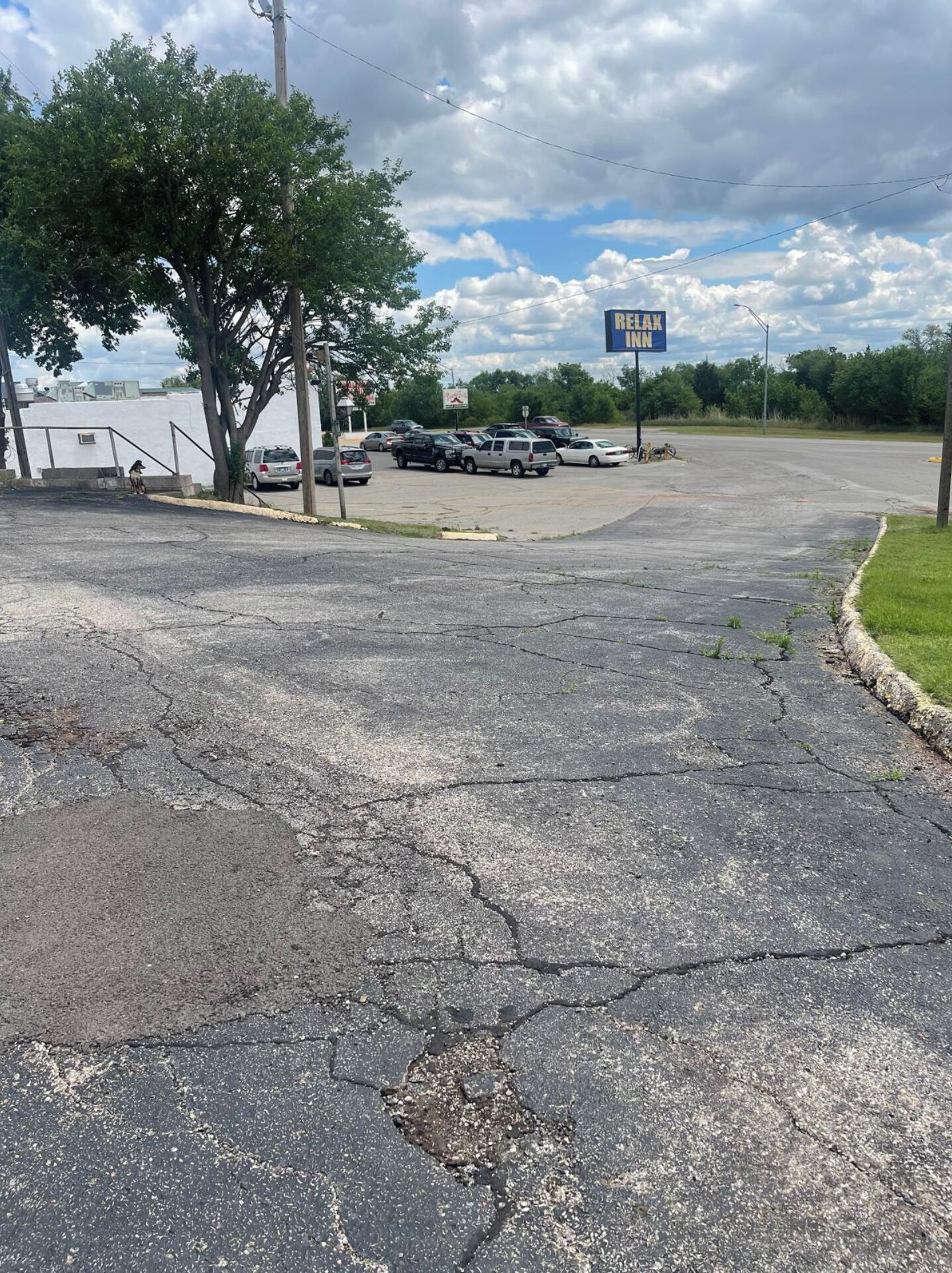 A parking lot with a sign for 'RE/MAX INN' and several parked vehicles.