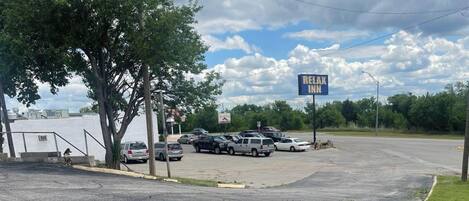 A parking lot with a sign for 'RE/MAX INN' and several parked vehicles.