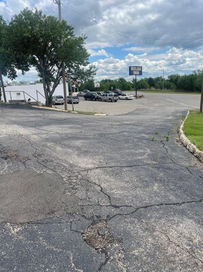 A parking lot with a sign for 'RE/MAX INN' and several parked vehicles.