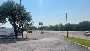 A parking lot with a sign for 'Relax Inn' in the distance. - Relax Inn (Clinton)