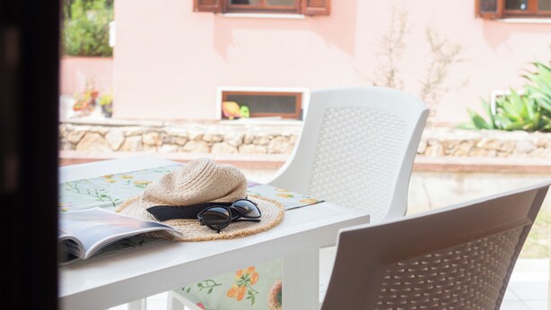 Una mesa con un sombrero de paja, gafas de sol y una revista.