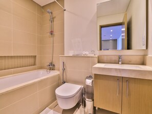 A modern bathroom with a bathtub, toilet, and sink.