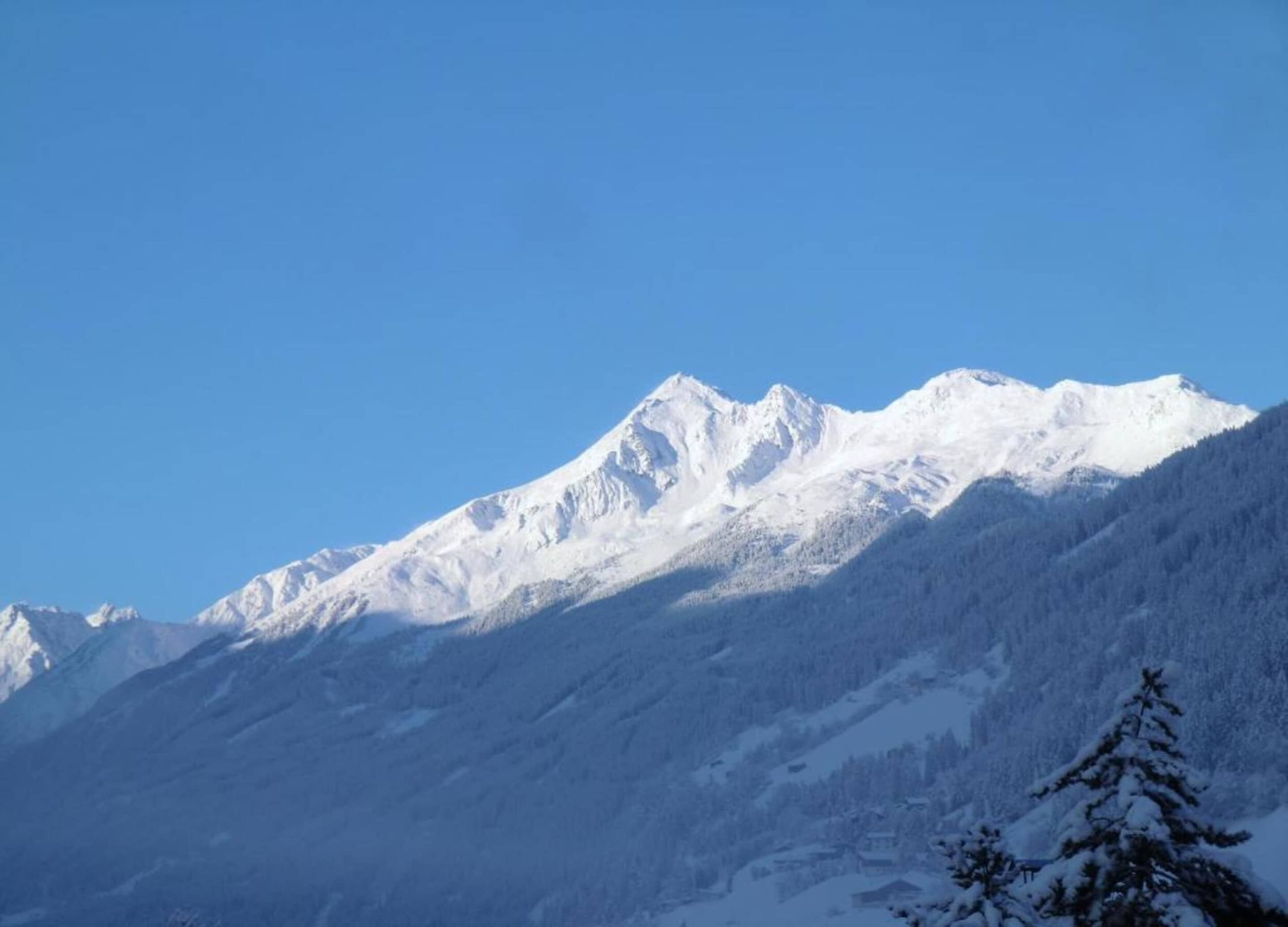 A snow-covered mountain range with clear skies.
