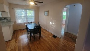 A dining area with a wooden table and chairs, a ceiling fan, and a window with lace curtains. - Do Not Book, VRBO sucks and won't let me delete this house I do not own anymore! (New Albany)