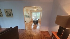 A spacious living area with hardwood flooring, a dining table with chairs, and a television on a wooden stand. - Do Not Book, VRBO sucks and won't let me delete this house I do not own anymore! (New Albany)