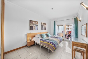 A modern bedroom with a bed, bedside tables, a desk, and a chair. - Pool and Sea View Apartment in Exclusive Condominium (Albufeira)