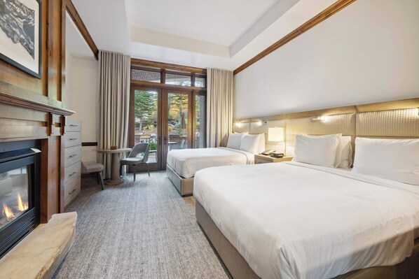 Relax in this stylish room with two single beds, a desk, and a fireplace, offering a peaceful view of the outdoors.