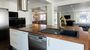 Una cocina moderna con campana de acero inoxidable, horno empotrado y lavavajillas.