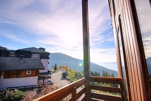 A balcony with a view of a mountain range and a road with cars. - 50m from ski slopes, 3rd floor, view resort, balcony, tv, 35m², Peisey-Vallandry (Landry)
