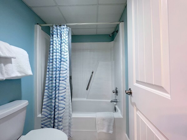 Une salle de bain avec une douche, des toilettes et un porte-serviettes.