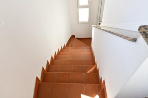 A staircase with terracotta tiles leading up to a white wall with a window. - Nice Apartment with Pool (Siracusa)
