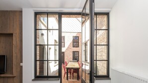 A room with a large sliding glass door leading to an outdoor patio with a table and chairs. - Modern Home by the Sea (Nieuwpoort)