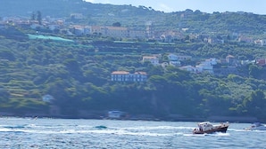 A coastal town with buildings on a hillside and boats on the water. - 3 Bedroom Apartment in Massa Lubrense (Massa Lubrense)