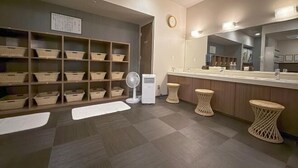 A modern bathroom with a large mirror, a sink, and storage baskets on shelves. - Hotel Route-Inn Hakata Ekimae -Hakataguchi- (Fukuoka)
