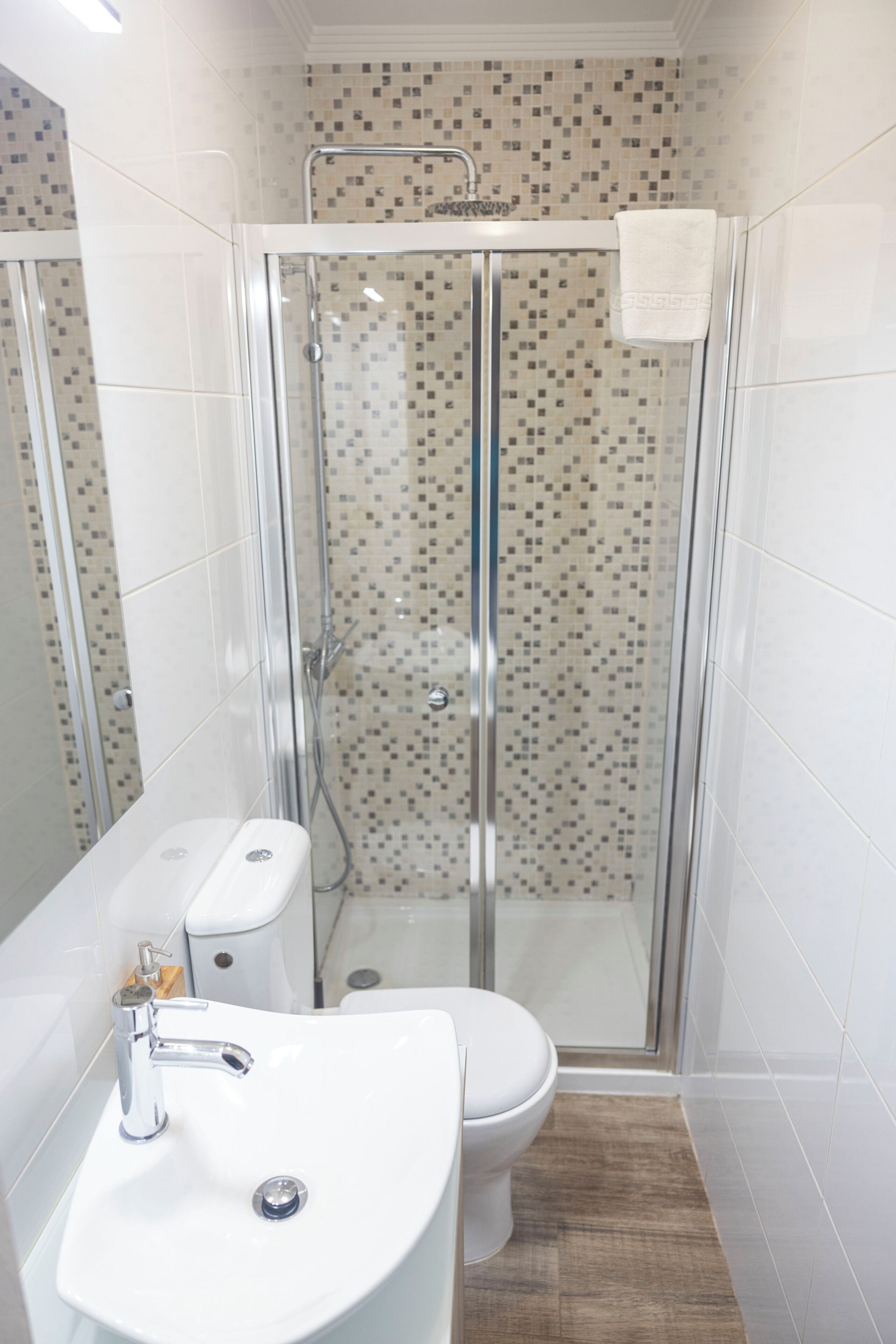Ein Badezimmer mit Duschkabine, Waschbecken in Weiß und Toilette.