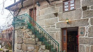 A stone building with a metal staircase, a wooden door, and a window. - GerêsTER  (Terras de Bouro)