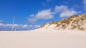 A beach with white sand and dunes under a clear blue sky. - 5 Star Holiday Home in Henne (Henne)