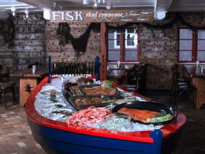 A seafood buffet with various dishes displayed on ice, including shrimp, salmon, and other seafood. - 4 Person Holiday Home in Gudhjem (Gudhjem)