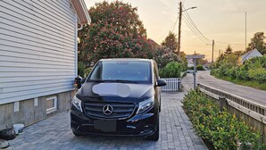 A black car parked on a paved driveway next to a house with a white exterior. - 6 Person Holiday Home in Skjaerhalden (Hvaler)