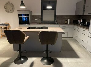 Huis | Privékeuken | Een oven, een waterkoker, een broodrooster, een kinderstoel
