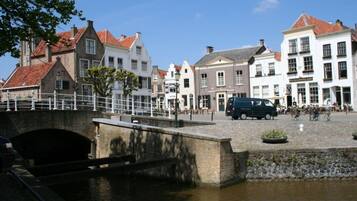 Una plaza histórica con un puente sobre un canal, rodeada de edificios europeos tradicionales.