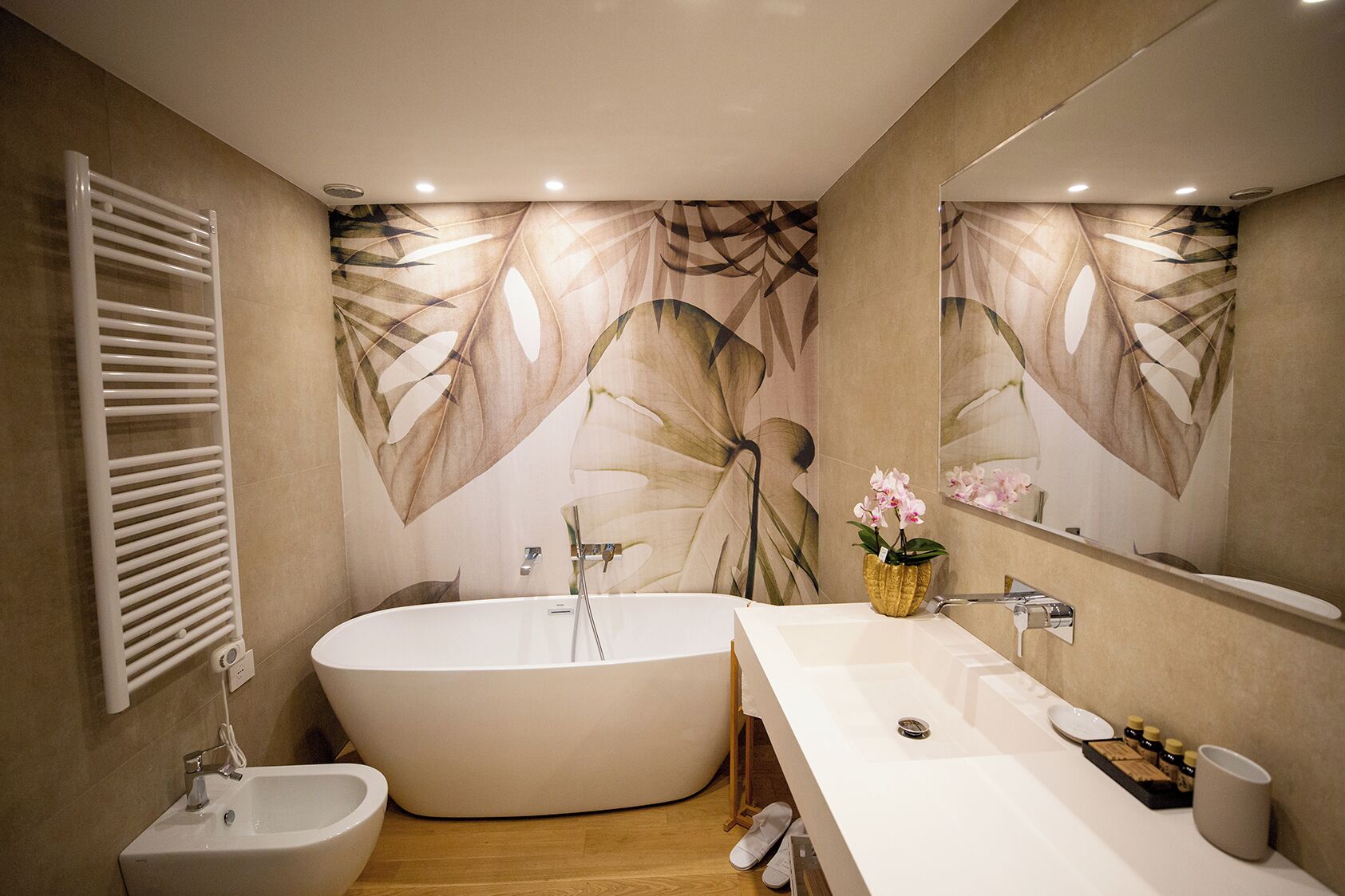 A modern bathroom with a freestanding bathtub, a white sink, and a vanity with a mirror.