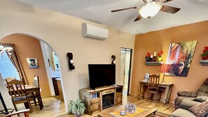 Una sala de estar con televisor, sofá, mesa de centro y chimenea.