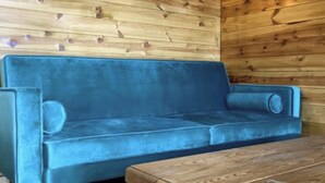 A blue sofa in a wooden cabin room. - Inviting 1-bed Cabin in Newmarket (Newmarket)