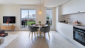 Una cocina moderna con comedor, televisor y vistas al exterior.