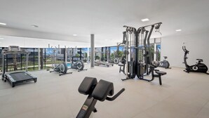 A modern gym with various exercise equipment, large windows, and a clean, spacious layout. - Apartment with sea view and gym (Estepona)