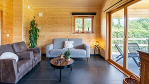 Een gezellig houten interieur met een bank, een bijzettafeltje en een plant.