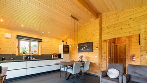 Een modern blokhut met een keuken, eethoek en woonkamer.