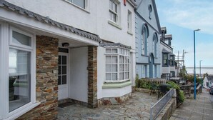 Une rangée de bâtiments blancs aux façades en pierre et aux grandes baies vitrées.
