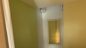 Een slaapkamer met een bed, een raam met uitzicht en een deur.