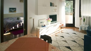 Un soggiorno moderno con un divano, una televisione e un'area pranzo con un tavolo.