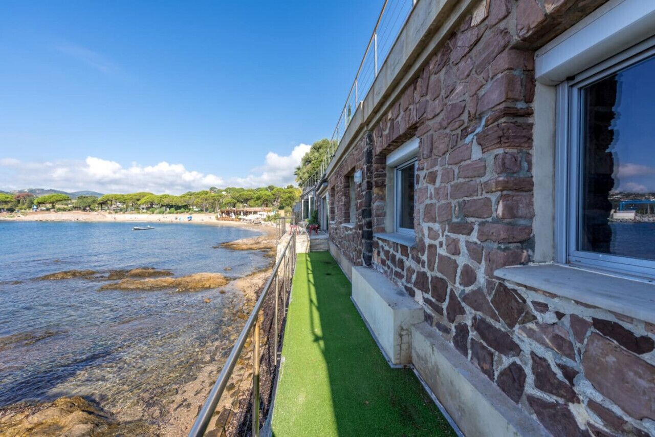 Un edificio in pietra con un balcone che si affaccia su una spiaggia.