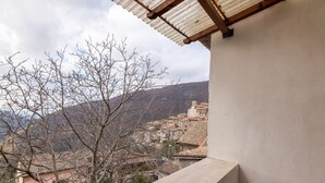 A balcony with a view of a hillside village and a tree in the foreground. - Belvilla by OYO Casa Romano (Polino)
