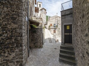 A narrow stone alleyway with a staircase leading to a building.