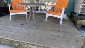A wooden deck with two orange chairs and a small round table. - SB#3: Dog Friendly, Across from the Beach, Free Daily Activities! (Pensacola)