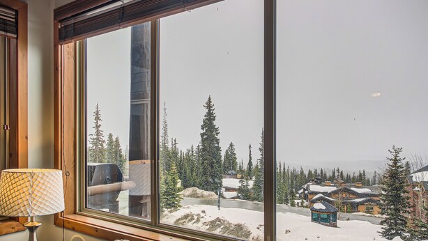A large window with a view of a snowy landscape, including trees and buildings. - Snowy Creek by Okanagan Premier (Beaverdell)