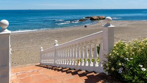 Une vue sur la mer avec une balustrade blanche et des marches menant à une plage.