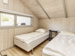 A compact room with two beds, a window, and wooden walls. - 4 Star Holiday Home in Praesto (Praesto)