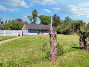 A fenced property with a house, a clear sky, and a grassy area. - 4 Star Holiday Home in Praesto (Praesto)