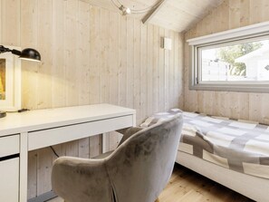 A room with a bed, a desk, a chair, and a window with a view of the outside. - 4 Star Holiday Home in Praesto (Praesto)