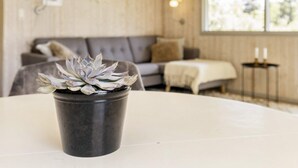 A room with a round table, a grey sofa, and a window with natural light. - 4 Star Holiday Home in Praesto (Praesto)