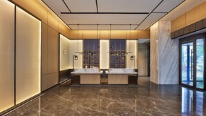 A modern bathroom with two sinks, a marble floor, and a large window.