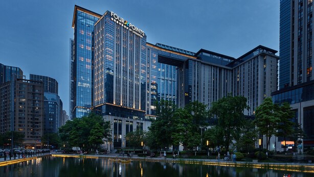 A modern hotel with a prominent glass facade and the name "FOUR POINTS" visible.